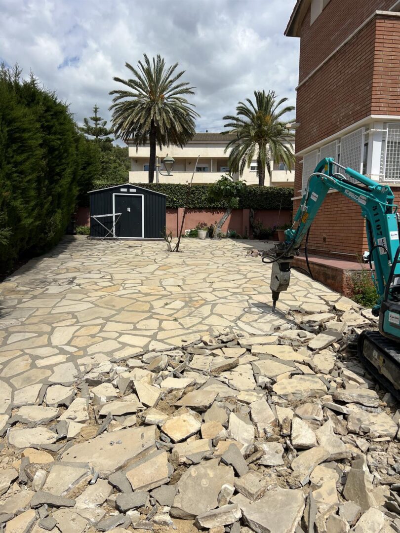 pavimentos de hormigón estampado en la Savinossa Tarragona (4) usamos una escavadora ligera con el accesorio de martillo hidraúlico para romper la piedra en mal estado